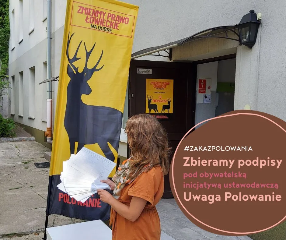 Aktywistka na podwórku przed siedzibą ODE Źródła, w tle winder z napisem Zmieńmy prawo łowieckie na dobre